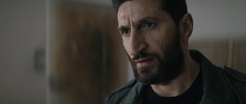 Movie still from “Department Q: A Conspiracy of Faith” (2016), directed by Hans Petter Moland – A person with a beard looking at the camera; Close Up shot, Over the shoulder angle