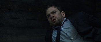 Movie still from “Department Q: A Conspiracy of Faith” (2016), directed by Hans Petter Moland – A person wearing a suit and tie; Close Up shot, Low angle