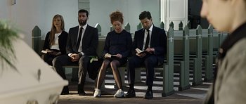 Movie still from “Department Q: A Conspiracy of Faith” (2016), directed by Hans Petter Moland – A group of people sitting next to each other on a bench; Wide shot, Low angle
