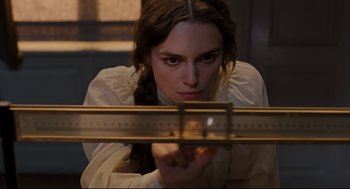 Movie still from “A Dangerous Method” (2011), directed by David Cronenberg – A woman in a white shirt is holding a ruler; Close Up shot, Overhead angle