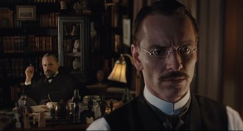 Movie still from “A Dangerous Method” (2011), directed by David Cronenberg – A man in a suit and tie standing in a room; Close Up shot, Low angle