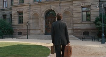 Movie still from “A Dangerous Method” (2011), directed by David Cronenberg – A man in a suit and tie holding a suit case; Wide shot, High angle
