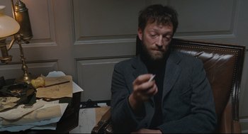 Movie still from “A Dangerous Method” (2011), directed by David Cronenberg – A man sitting in a chair holding a cigarette in his hand; Medium shot, High angle