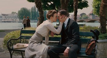 Movie still from “A Dangerous Method” (2011), directed by David Cronenberg – A man and a woman sitting on top of a wooden bench; Medium shot, Low angle