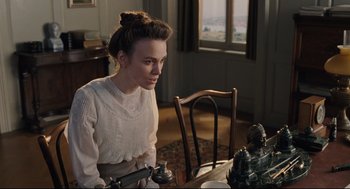 Movie still from “A Dangerous Method” (2011), directed by David Cronenberg – A woman sitting at a dining room table; Medium shot, High angle