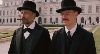 Movie still from “A Dangerous Method” (2011), directed by David Cronenberg – A couple of men in black suits and hats; Medium shot, Low angle