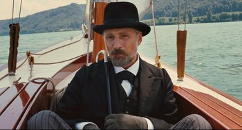 Movie still from “A Dangerous Method” (2011), directed by David Cronenberg – A man in a suit and hat holding an umbrella on a sailboat; Close Up shot, Low angle