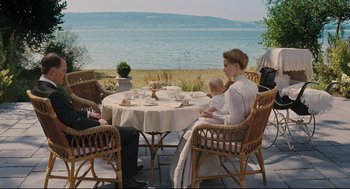 Movie still from “A Dangerous Method” (2011), directed by David Cronenberg – A group of people sitting at a table with food; Wide shot, High angle