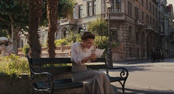 Movie still from “A Dangerous Method” (2011), directed by David Cronenberg – A woman sitting on a bench looking at a piece of paper; Wide shot, Low angle