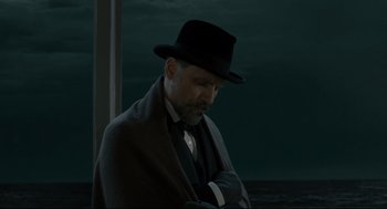 Movie still from “A Dangerous Method” (2011), directed by David Cronenberg – A man in a black hat and a black coat; Medium shot, Low angle