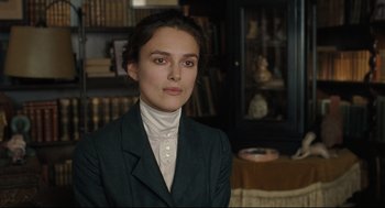 Movie still from “A Dangerous Method” (2011), directed by David Cronenberg – A woman wearing a suit and standing in front of a bookcase; Close Up shot, Over the shoulder angle