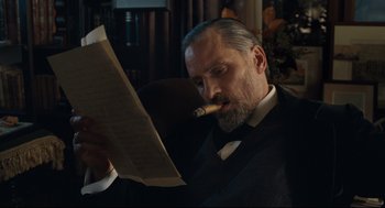 Movie still from “A Dangerous Method” (2011), directed by David Cronenberg – An older man smoking a cigar while reading a paper; Close Up shot, Low angle
