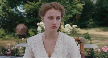Movie still from “A Dangerous Method” (2011), directed by David Cronenberg – A woman in a white dress sitting in a chair; Close Up shot, Over the shoulder angle