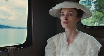 Movie still from “A Dangerous Method” (2011), directed by David Cronenberg – A woman wearing a white hat sitting in front of a window; Close Up shot, Low angle