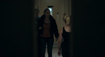 Movie still from “A Date for Mad Mary” (2016), directed by Darren Thornton – A group of people walking down a hall way; Medium shot, Over the shoulder angle