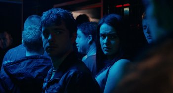 Movie still from “A Date for Mad Mary” (2016), directed by Darren Thornton – A man and a woman standing next to each other in a dark room; Close Up shot, Over the shoulder angle