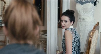 Movie still from “A Date for Mad Mary” (2016), directed by Darren Thornton – A woman standing in front of a mirror holding a wine glass; Close Up shot, Over the shoulder angle