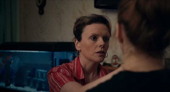Movie still from “A Date for Mad Mary” (2016), directed by Darren Thornton – A woman in a red striped shirt looking at her reflection in a mirror; Close Up shot, Over the shoulder angle