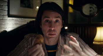 Movie still from “A Date for Mad Mary” (2016), directed by Darren Thornton – A man holding a donut in his hands; Close Up shot, Low angle