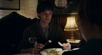 Movie still from “A Date for Mad Mary” (2016), directed by Darren Thornton – A man sitting in front of a plate of food at a restaurant; Medium shot, Over the shoulder angle