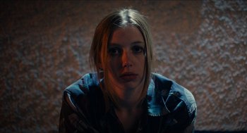 Movie still from “A Date for Mad Mary” (2016), directed by Darren Thornton – A woman sitting on the ground in front of a brick wall; Close Up shot, Low angle