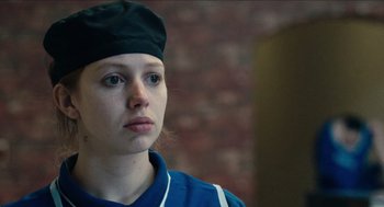 Movie still from “A Date for Mad Mary” (2016), directed by Darren Thornton – A woman wearing a black hat and a blue shirt; Close Up shot, Low angle