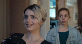 Movie still from “A Date for Mad Mary” (2016), directed by Darren Thornton – A woman with short blonde hair is smiling at the camera; Close Up shot, Over the shoulder angle