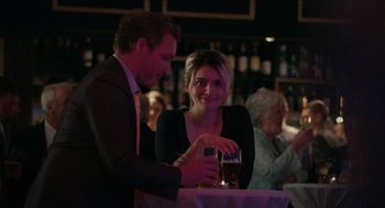Movie still from “A Date for Mad Mary” (2016), directed by Darren Thornton – A man and a woman at a table with a glass of beer; Medium shot, Over the shoulder angle