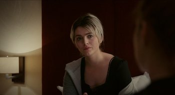 Movie still from “A Date for Mad Mary” (2016), directed by Darren Thornton – A woman sitting in a chair looking at the camera; Close Up shot, Over the shoulder angle