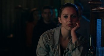 Movie still from “A Date for Mad Mary” (2016), directed by Darren Thornton – A woman sitting in front of a group of other people; Close Up shot, Over the shoulder angle