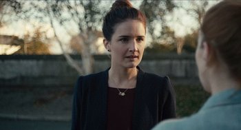 Movie still from “A Date for Mad Mary” (2016), directed by Darren Thornton – A young woman wearing a black jacket and a red shirt; Close Up shot, Over the shoulder angle