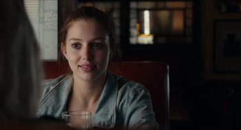 Movie still from “A Date for Mad Mary” (2016), directed by Darren Thornton – A woman sitting at a table with a glass of water; Close Up shot, Over the shoulder angle