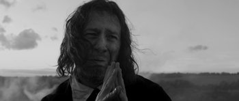 Movie still from “A Field in England” (2013), directed by Ben Wheatley – Black and white photograph of a man with long hair; Close Up shot, Low angle