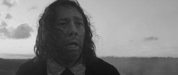 Movie still from “A Field in England” (2013), directed by Ben Wheatley – A black and white photo of a man with long hair; Close Up shot, Low angle