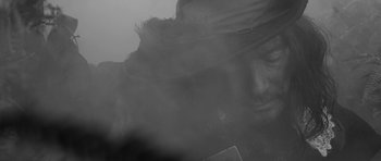 Movie still from “A Field in England” (2013), directed by Ben Wheatley – A man with a hat and a beard in the fog; Extreme Close Up shot, Low angle