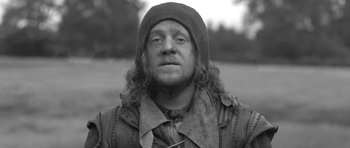 Movie still from “A Field in England” (2013), directed by Ben Wheatley – Black and white photograph of a man with long hair; Close Up shot, Low angle