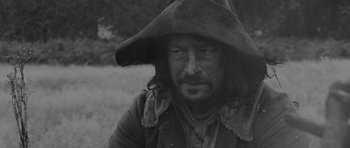 Movie still from “A Field in England” (2013), directed by Ben Wheatley – A black and white photo of a man wearing a pirate hat; Close Up shot, Over the shoulder angle