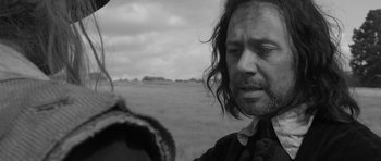Movie still from “A Field in England” (2013), directed by Ben Wheatley – A black and white photo of a man and a woman in a field; Close Up shot, Over the shoulder angle