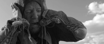 Movie still from “A Field in England” (2013), directed by Ben Wheatley – A black and white photo of a man with a beard; Close Up shot, Over the shoulder angle
