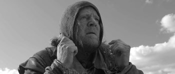 Movie still from “A Field in England” (2013), directed by Ben Wheatley – An old man with a beard and a hooded jacket; Close Up shot, Low angle