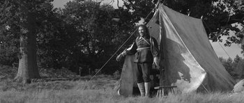Movie still from “A Field in England” (2013), directed by Ben Wheatley – A man standing in front of a tent in a field; Wide shot, Low angle