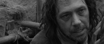 Movie still from “A Field in England” (2013), directed by Ben Wheatley – A person with long hair; Close Up shot, Low angle