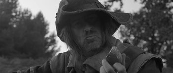 Movie still from “A Field in England” (2013), directed by Ben Wheatley – A person holding a piece of food; Close Up shot, Low angle