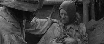 Movie still from “A Field in England” (2013), directed by Ben Wheatley – A man in a hooded jacket and a man in a hat; Medium shot, High angle