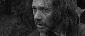 Movie still from “A Field in England” (2013), directed by Ben Wheatley – Black and white photograph of a man with long hair; Close Up shot, Low angle