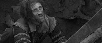 Movie still from “A Field in England” (2013), directed by Ben Wheatley – A black and white photo of a man with a beard; Medium shot, Low angle