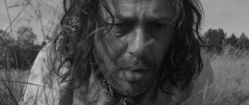 Movie still from “A Field in England” (2013), directed by Ben Wheatley – Black and white photograph of a man with long hair; Extreme Close Up shot, Low angle