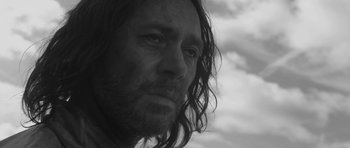 Movie still from “A Field in England” (2013), directed by Ben Wheatley – Black and white photograph of a man with long hair; Close Up shot, Low angle