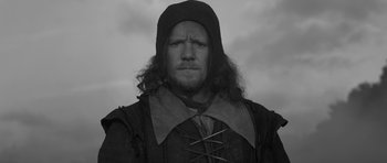 Movie still from “A Field in England” (2013), directed by Ben Wheatley – A black and white photo of a man with a beard; Close Up shot, Low angle