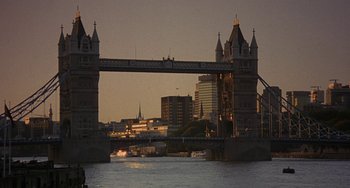 Movie still from “A Fish Called Wanda” (1988), directed by Charles Crichton – A view of a bridge that is over a body of water; Extreme Wide shot, Low angle